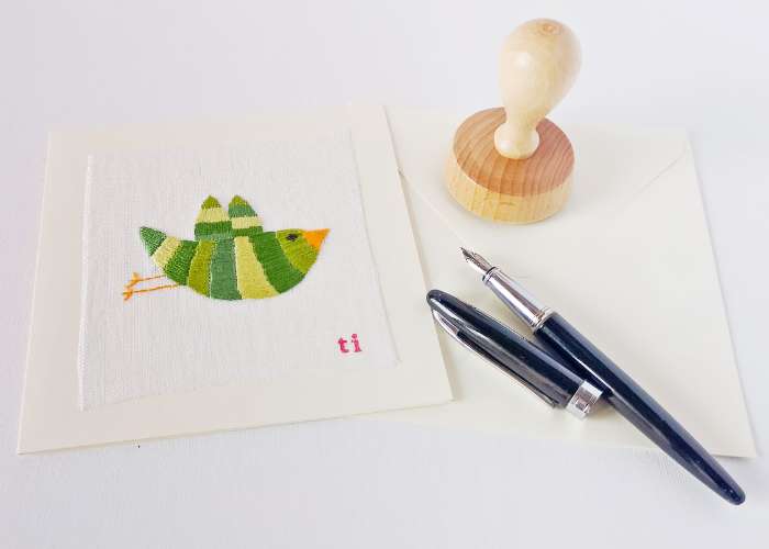 Green embroidered bird card